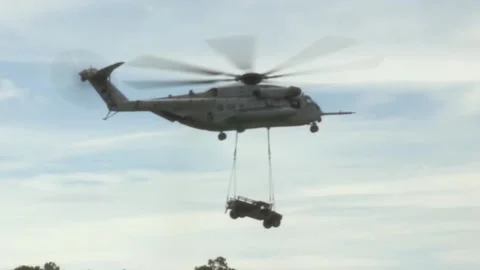 Soft Focus of a Super Stallion Helicopter Dropping a Jeep off Stock Footage 130587799