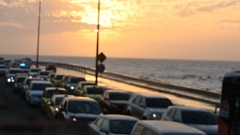 Soft focus of traffic jam on a coastal road at sunset, sea wave crashing Stock Footage 126550160