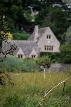 Soft-focus view of historic Cotswold cottage framed by meadow plants Stock Photos