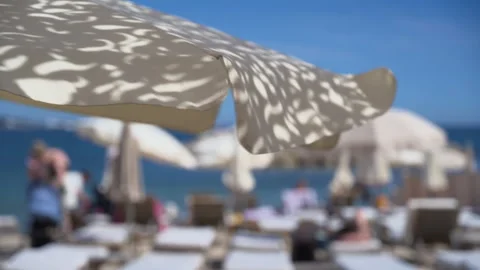 Soft focus view of an upscale beachfront resort featuring rows of sun loungers, Stock Footage 336974278