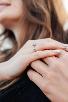 Soft focus on a woman's hands, one adorned with a simple ring Foto stock