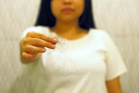 Soft focus to Young woman with hair loss problem on hand in Toilet Stock Photos