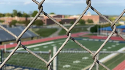 Soft focused high school field with foreground fence Stock Footage 139955460
