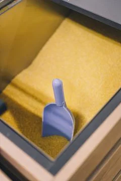 Soft focused vertical shot of blue plastic scoop in some yellow groats Stock Photos