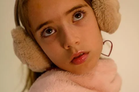 Soft fur ear muffs frame a child's gentle gaze Stock Photos