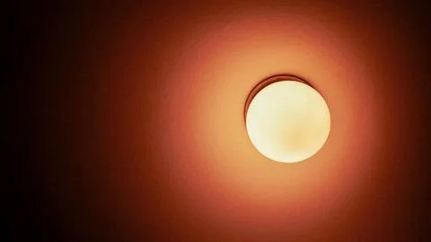 Soft glow emanating from a round ceiling light, casting warm hues in a cozy.. Stock Photos