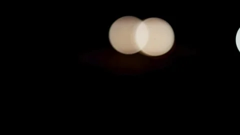 Soft glowing bokeh lights move across dark black background Stock Footage 329816297