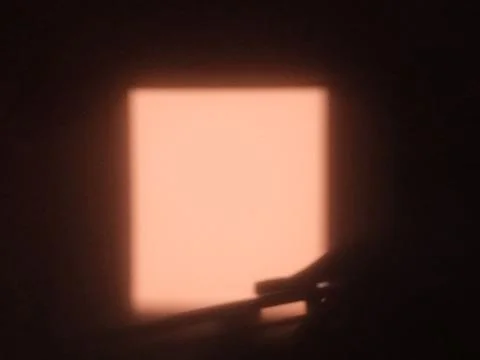 Soft glowing rectangular light in dark room with warm peach tone and silhouette Stock Photos