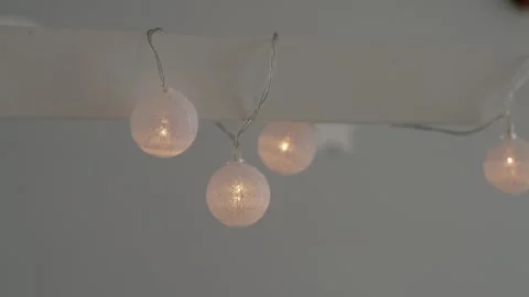 Soft glowing string lights hanging gently in minimal interior space 스톡 동영상 310662059