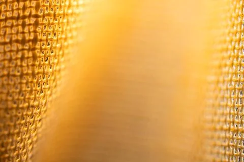 Soft golden abstract background framed by blurred metallic mesh edges with .. Stock Photos