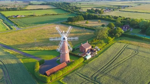 Soft golden light warms the windmill's stone base 스톡 동영상 342614328