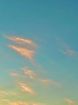 Soft Golden Sunset Clouds Floating Across a Clear Blue Sky During Twilight Hours Stock Photos