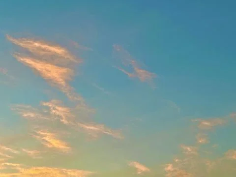 Soft Golden Sunset Clouds Floating Across a Clear Blue Sky During Twilight Hours Stock Photos
