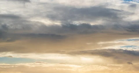 Soft golden yellow clouds time lapse moving right to left across the sky Stock Footage 146054984