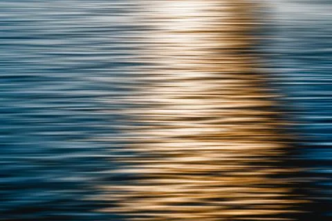 Soft gradient of warm light and cool water creates a peaceful effect. Stock-Fotos