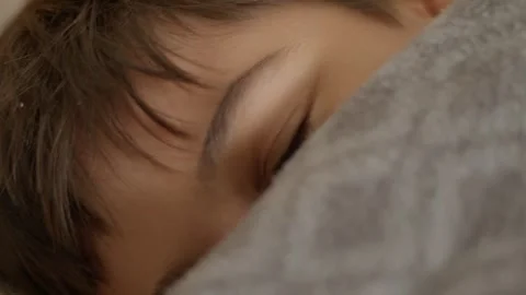 Soft gray blanket covers a smiling sleeping child Stock Footage 342191819