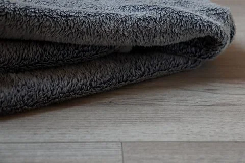 Soft gray towel placed on light wooden floor in a bright and cozy room Foto stock