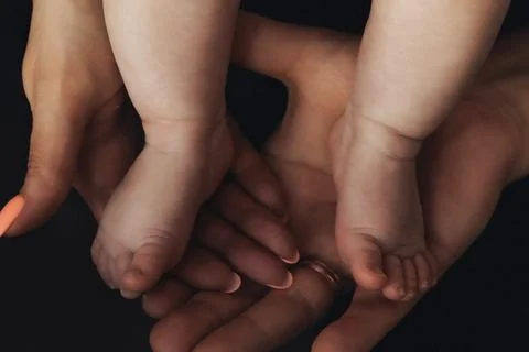 Soft hands cradle tiny feet with gentle care 스톡 사진