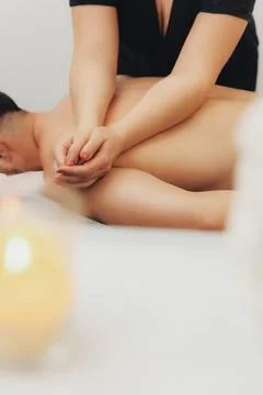 Soft hands massage a person's back gently Stock Photos
