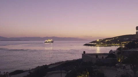 Soft hues paint the sky as a ship sails away from the charming island of Donousa Stock Footage 281370362