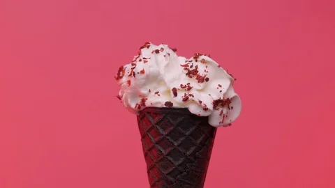 Soft ice cream in black cone decorated with chips over pink background Stock Footage 108800773