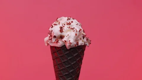 Soft ice cream in black cone decorated with chips over pink background Stock Footage 108800848