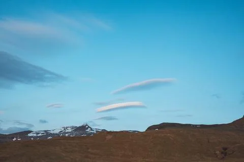 Soft lenticular clouds float above snowy peaks in West Iceland Stock Photos