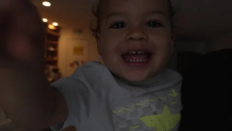 Soft light casts gentle shadows on a laughing child being spun around by his dad Stock Footage 333411120