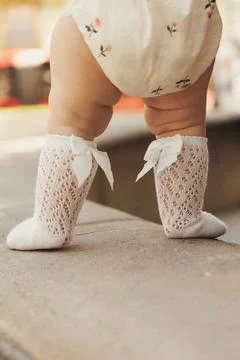 Soft light catches tiny feet in delicate lace socks Stock Photos