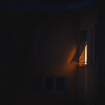 Soft light coming out of a window at night Stock Photos