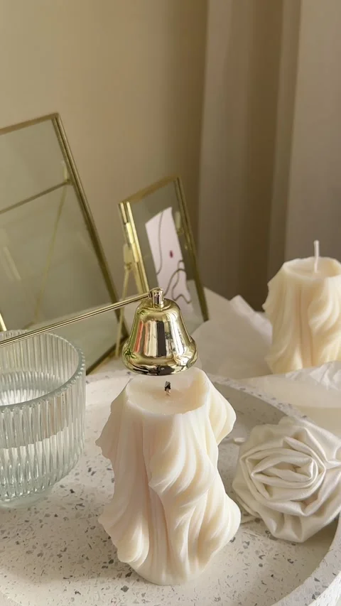Soft light flickers from unique textured candles set on a stylish tabletop Vidéo 340760175