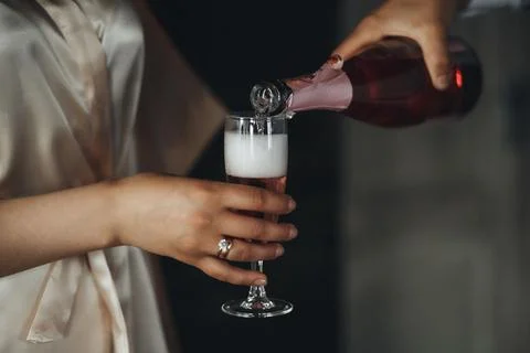 Soft light glows on hands pouring sparkling wine Foto stock