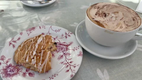 Soft light glows over breakfast scene with cappuccino and partially eaten f.. Stock Footage 337654984
