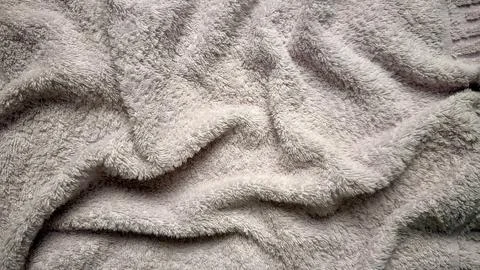 Soft light gray fluffy terry cloth, texture with elegant folds for background Stock Photos