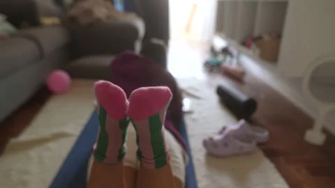 Soft light illuminates feet in peaceful exercise setting at home Stock Footage 346478838