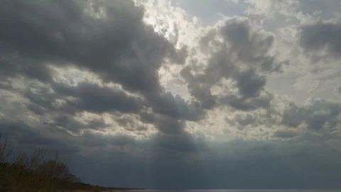 Soft light over ocean with gathering storm clouds, muted tones and diffuse rays Stock Footage 334012471