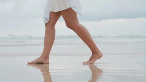 Soft light white woman strolling island shoreline, graceful leg movement and wet Stock Footage 335167310
