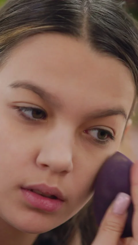 Soft makeup application, Young woman meticulously blends foundation and Stock Footage 329478300