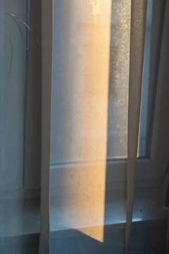 Soft morning light streaming through sheer curtains onto a windowsill, creating Stock Photos