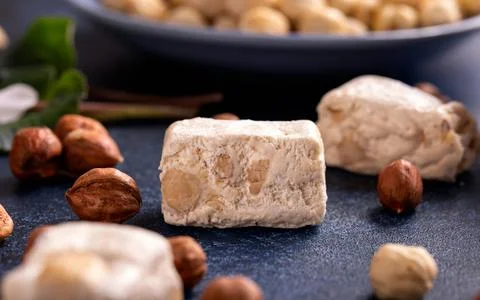 Soft nougats with hazelnuts on rustic table Stock Photos