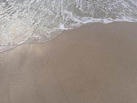 Soft Ocean Wave with White Foam Washing on Sandy Beach Stock Photos