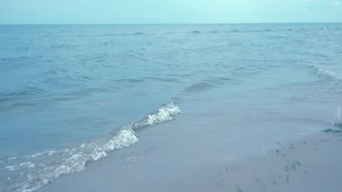 Soft Ocean Waves Rolling Onto Sandy Beach Under Clear Sky Stock Footage 340581122