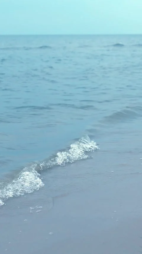 Soft Ocean Waves Rolling Onto Sandy Beach Under Clear Sky Stock Footage 340624402