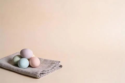 Soft pastel colored Easter eggs arranged on a linen cloth with a neutral ba.. Stock Photos