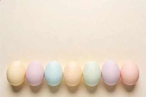 Soft pastel Easter eggs arranged in a row on a neutral background, celebrat.. Stock Photos
