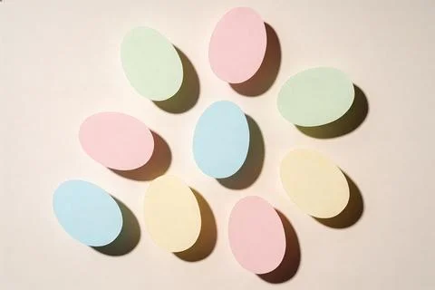 Soft pastel Easter eggs arranged in a circular pattern with dramatic shadows Stock Photos