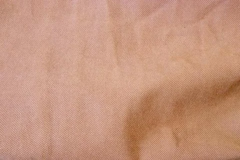 Soft peach fabric texture with a subtle pattern, perfect for backgrounds or Stock Photos