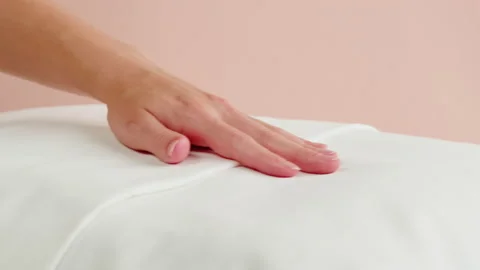 Soft pillow close-up. Touching white cushion on pink background. Healthy Stock Footage 205897135