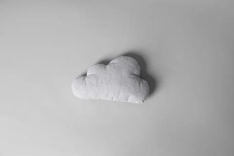 Soft pillow in shape of cloud on light background Stock Photos