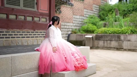 Soft pink and white hanbok draped over stone steps Stock Footage 340950259